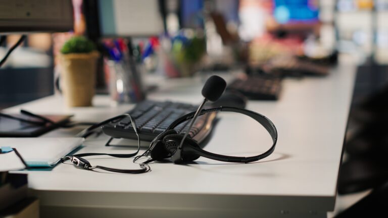 Headset with microphone on an office desk beside a keyboard